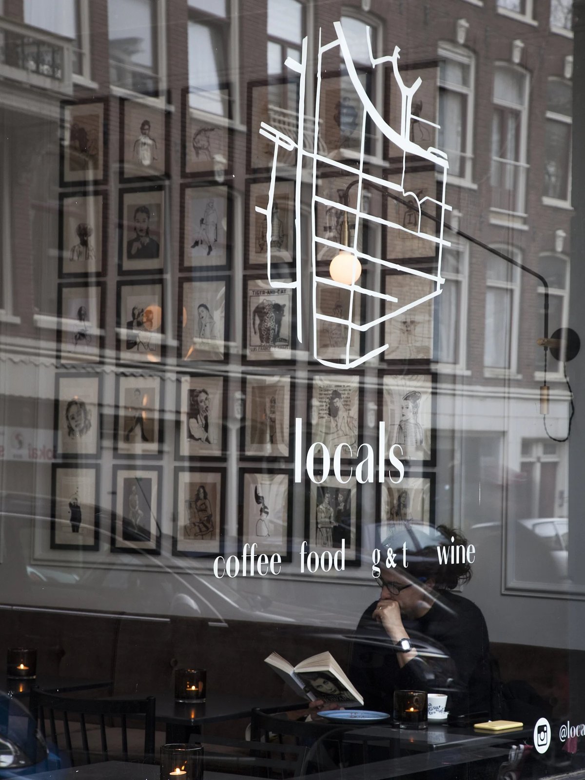 Café Locals street view with window logo and art wall inside.