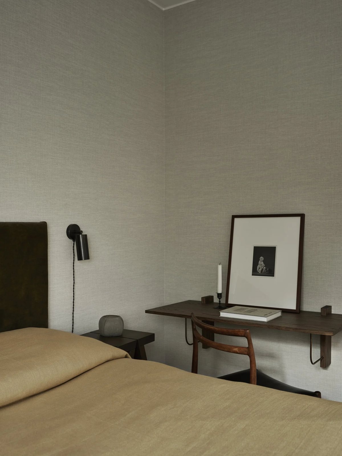 Floating walnut desk with vintage chair in calm bedroom corner