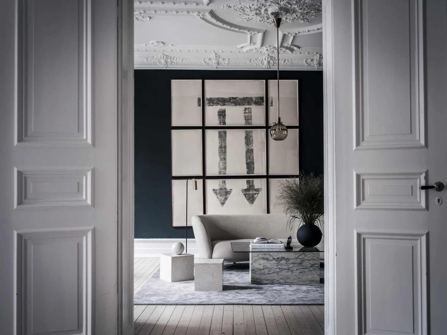 A bright living room blending ornate plasterwork ceiling and modern art.