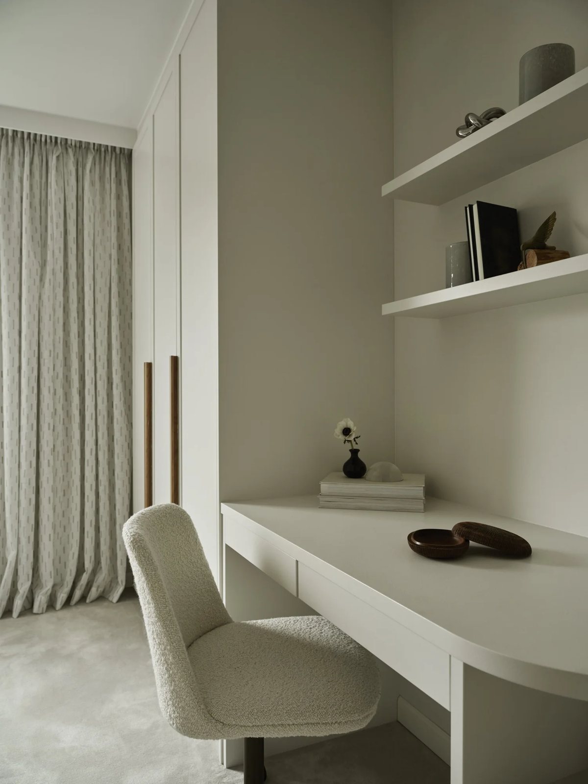 White built-in desk with boucle chair and open shelving