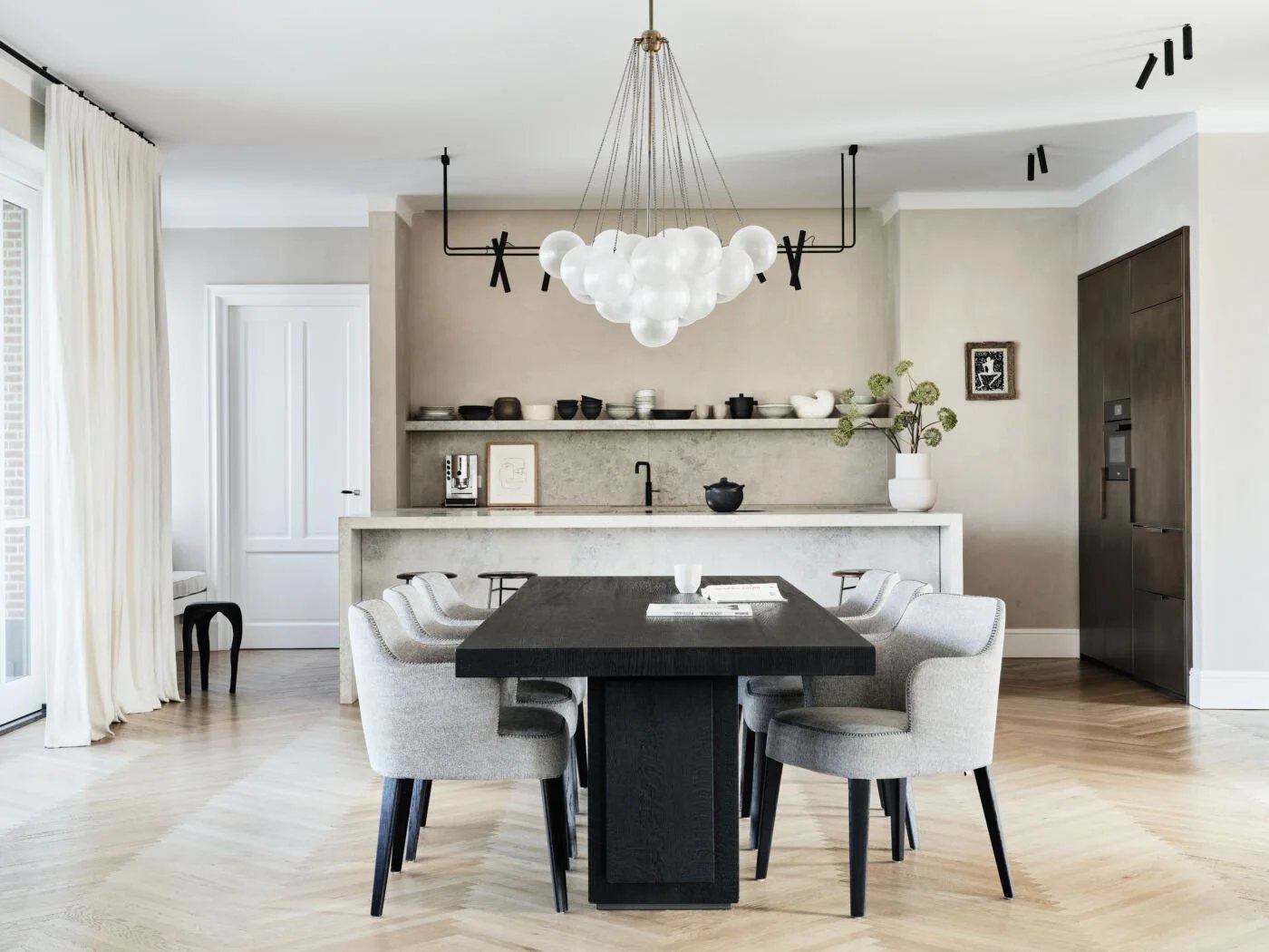 Modern dining room with black oak table and cloud-like chandelier.