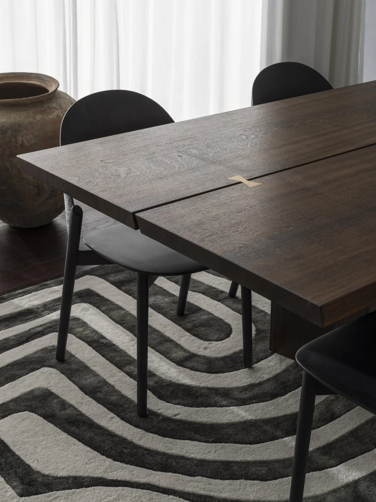 Dining table with brass inlay and patterned rug