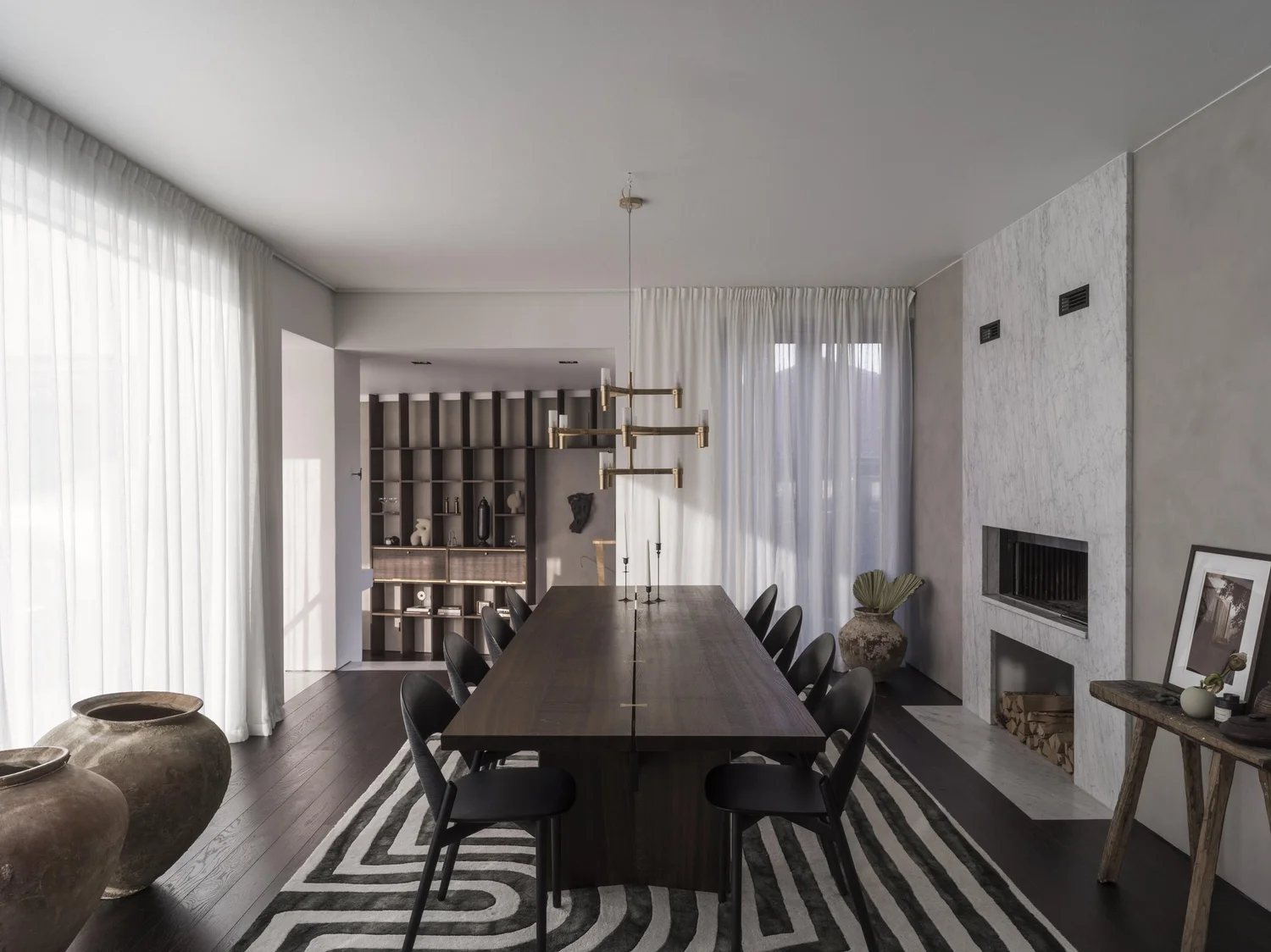 Modern space with dark oak table, brass details, and sculptural decor