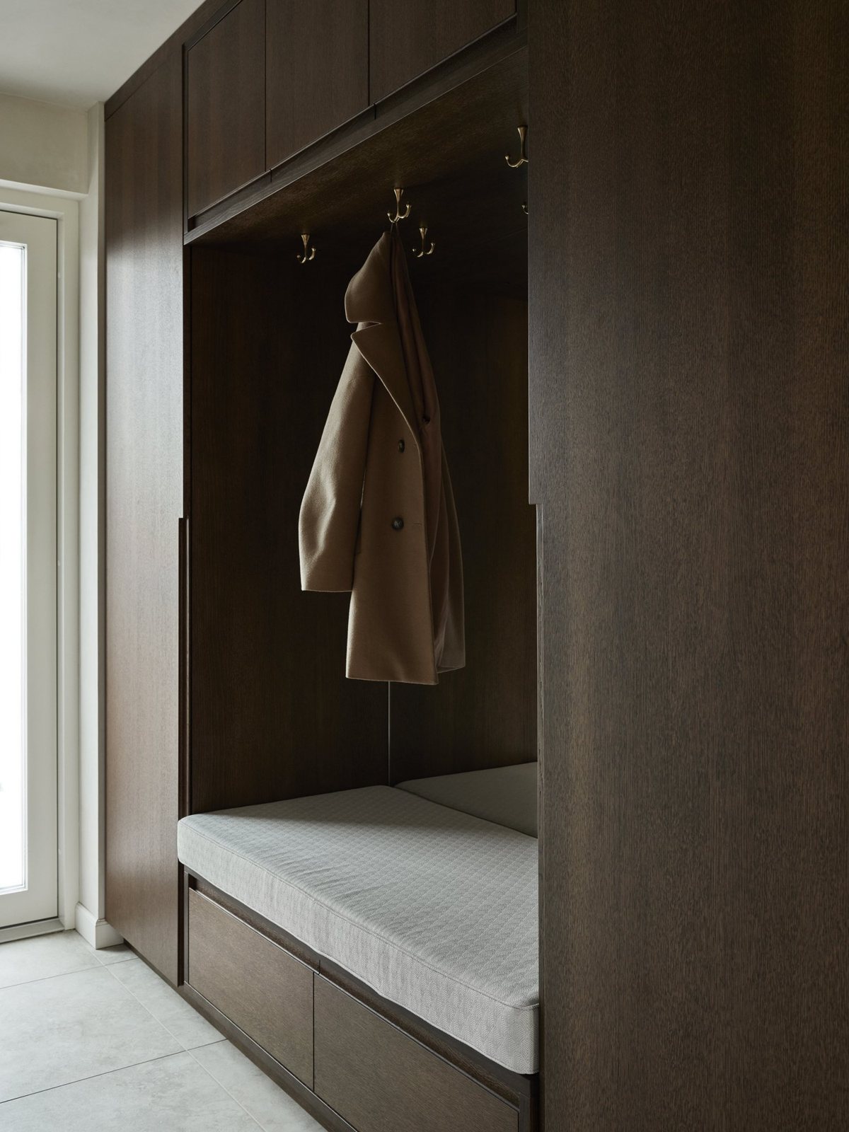 Dark oak hallway cabinet with coat hooks and soft bench cushion