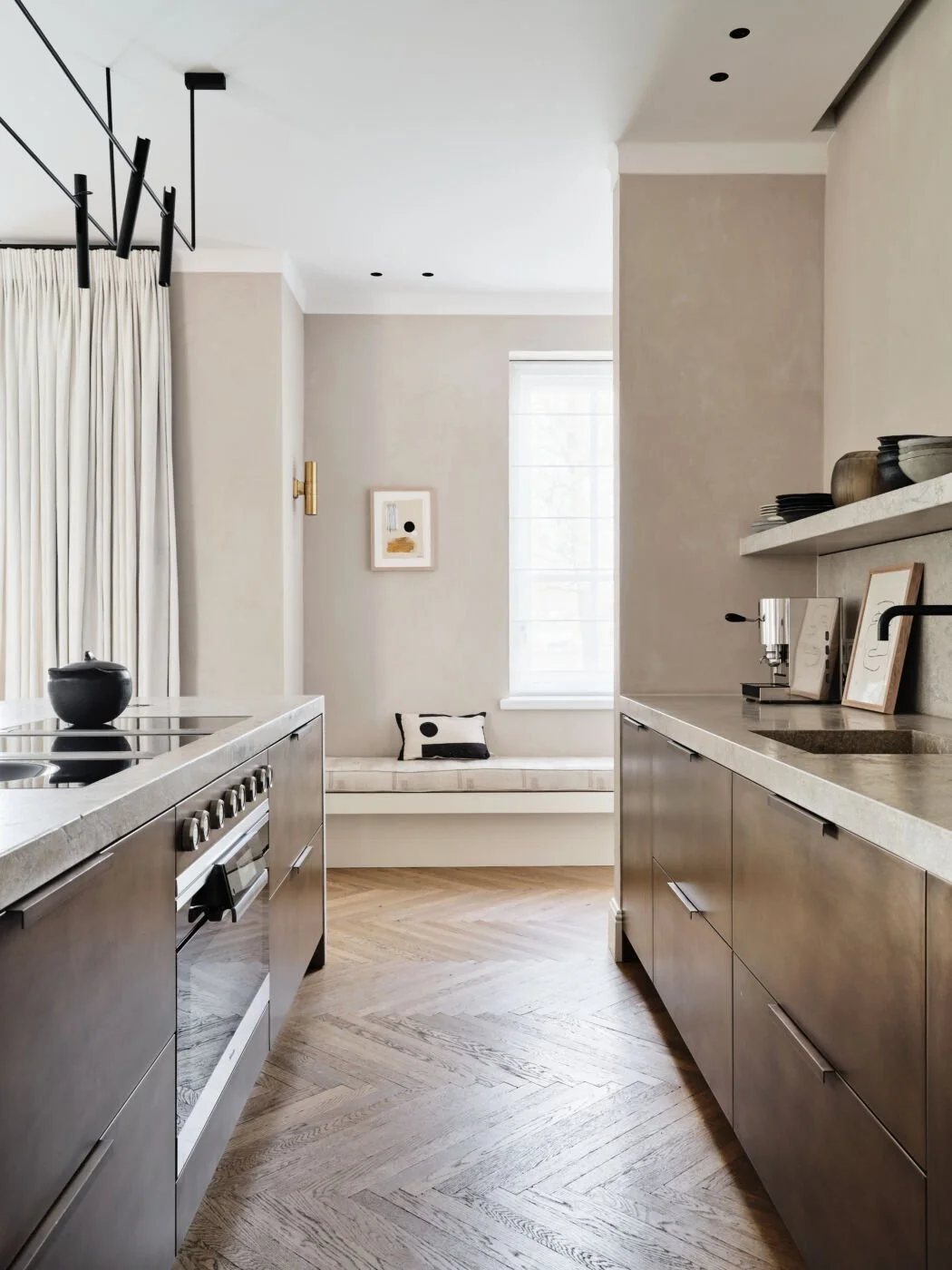 Streamlined galley kitchen with dark stone counters and integrated seating nook.